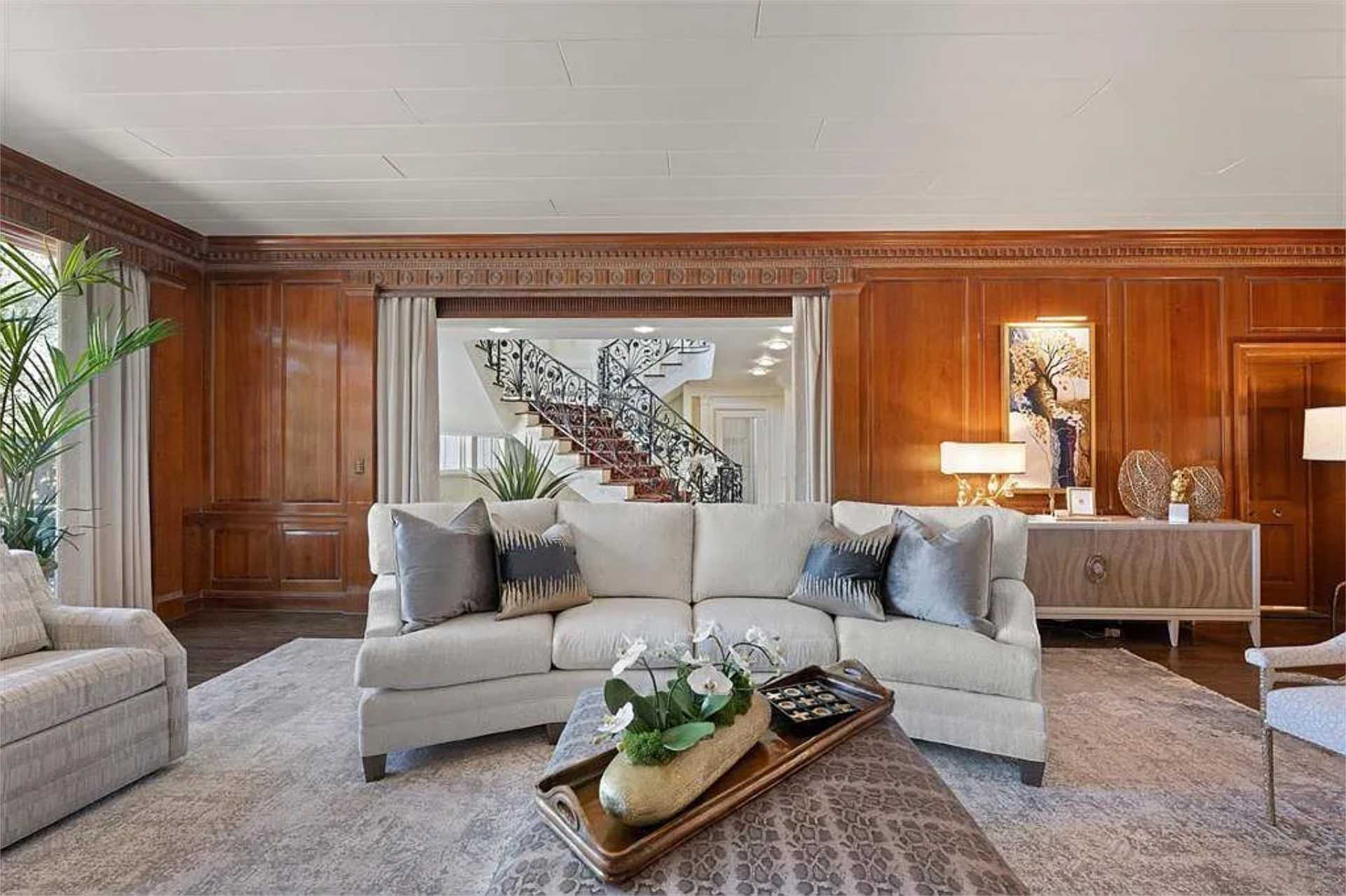 Paneled sitting room framing the wrought-iron staircase