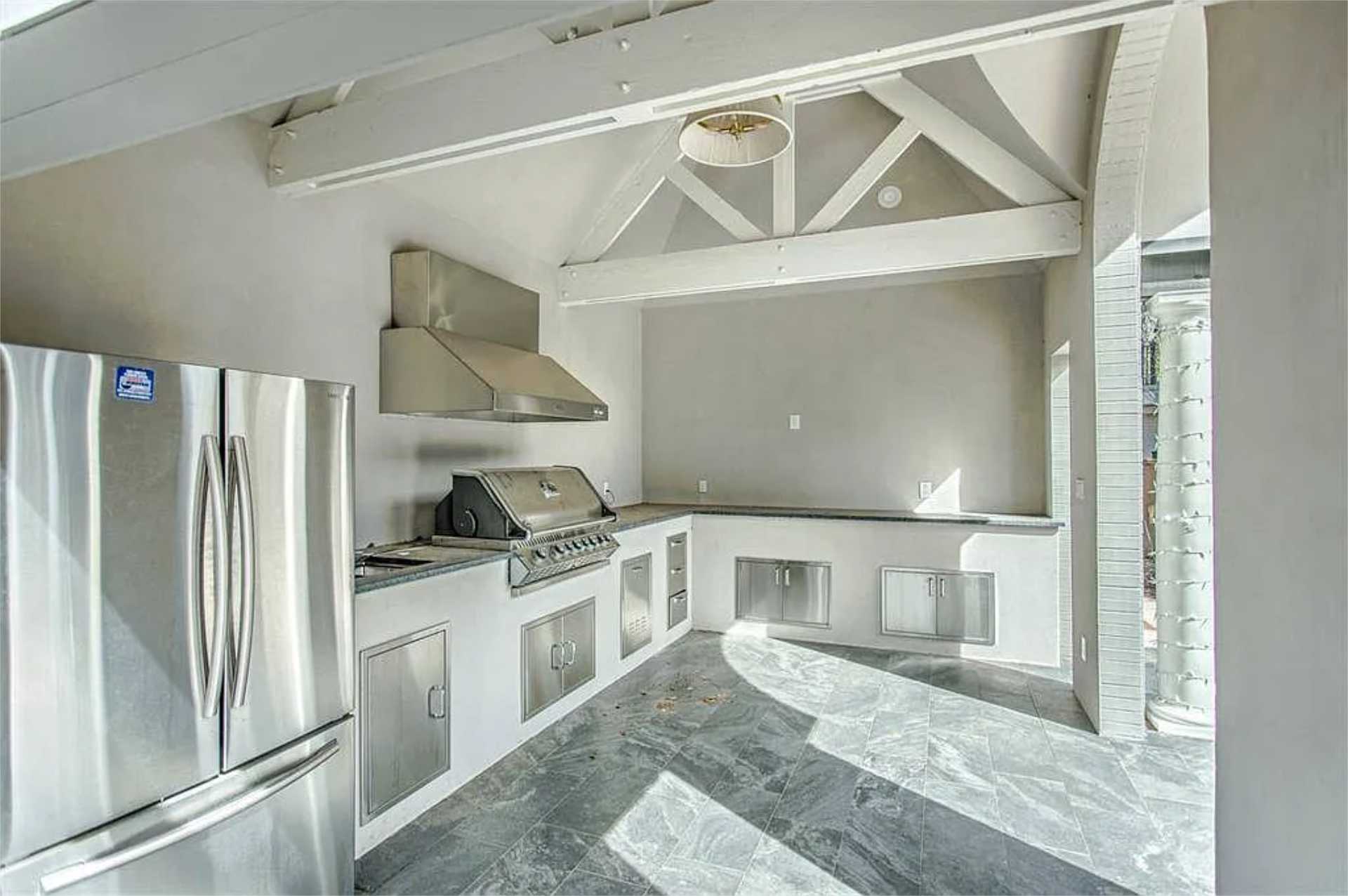 Outdoor kitchen with vaulted ceiling and stainless appliances