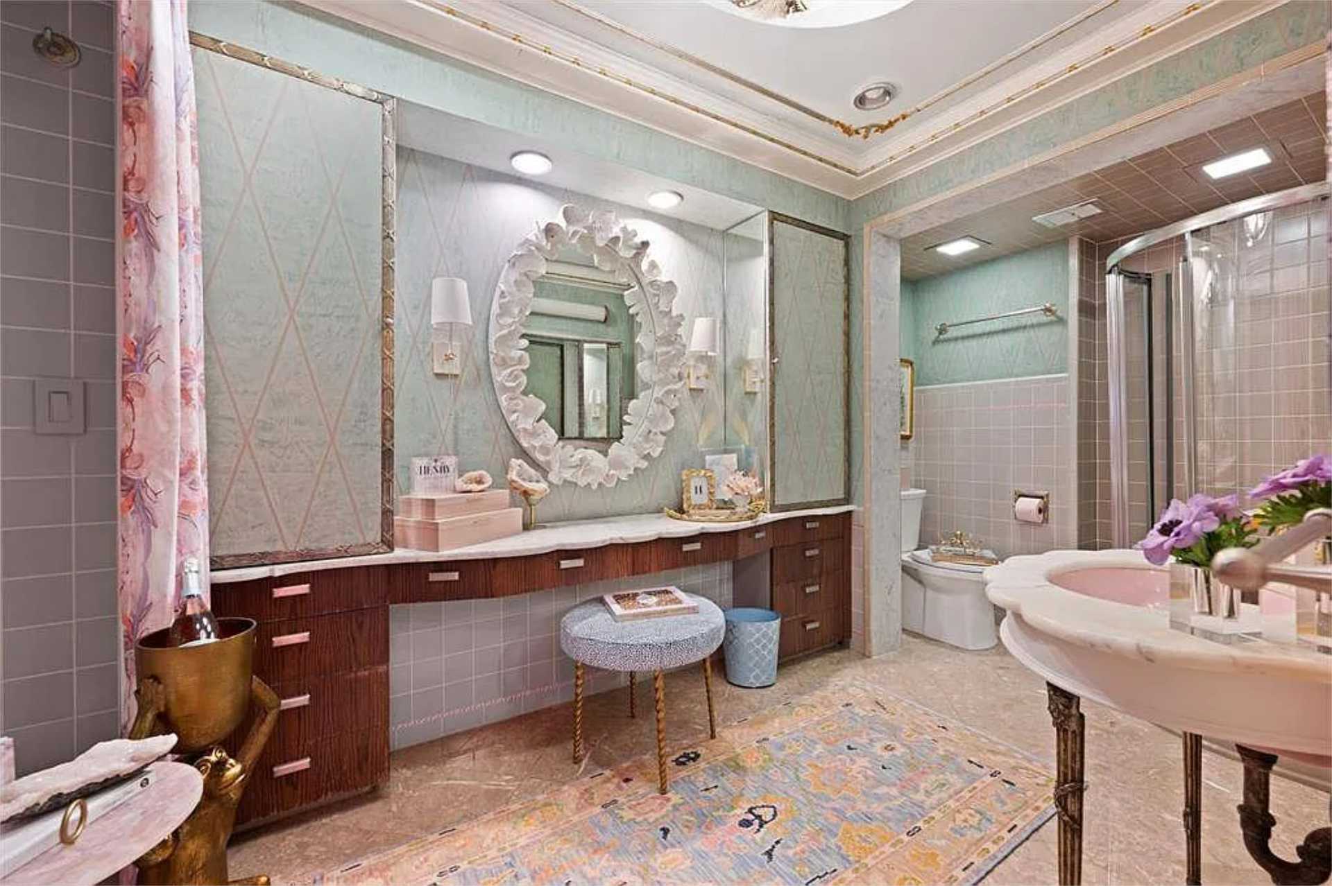 Pastel powder bath with ornate mirror and marble vanity