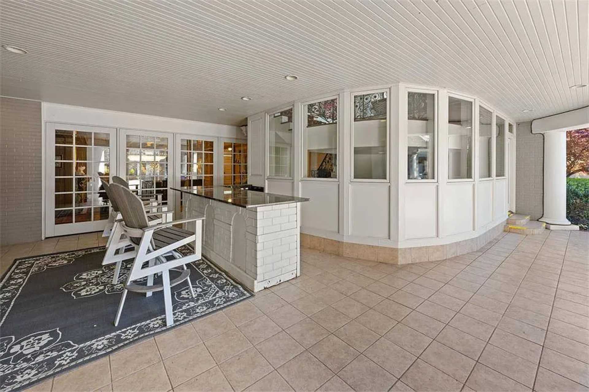 Covered loggia with built-in bar and garden views