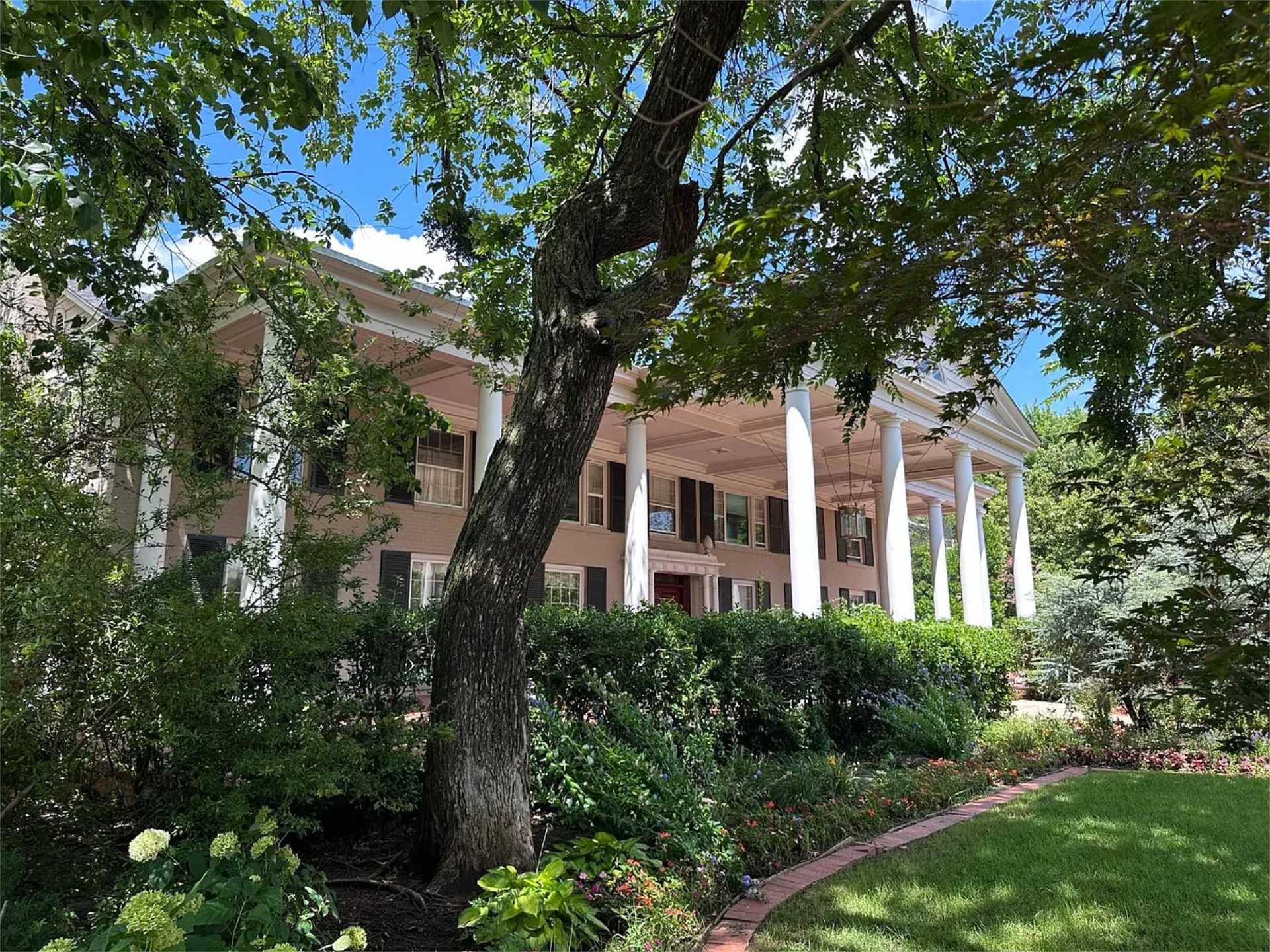 Front portico framed by mature trees