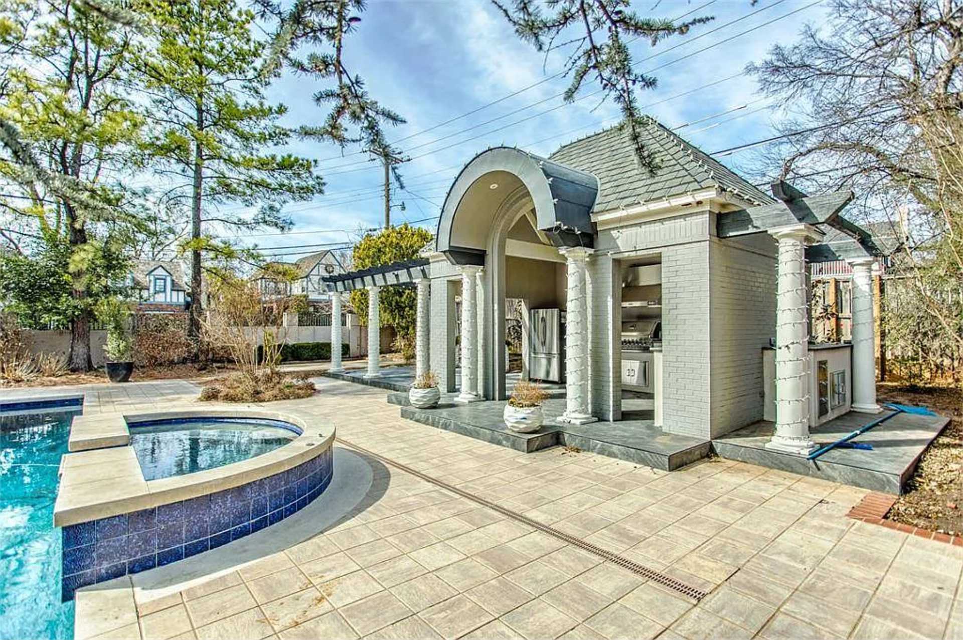 Spa and arched pool pavilion with outdoor kitchen